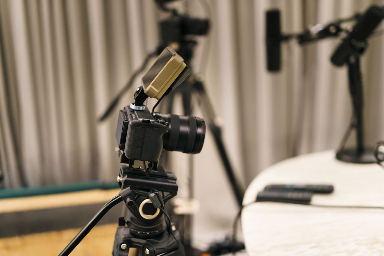 Close-up of a camera and microphone in a professional podcast studio, highlighting equipment setup.