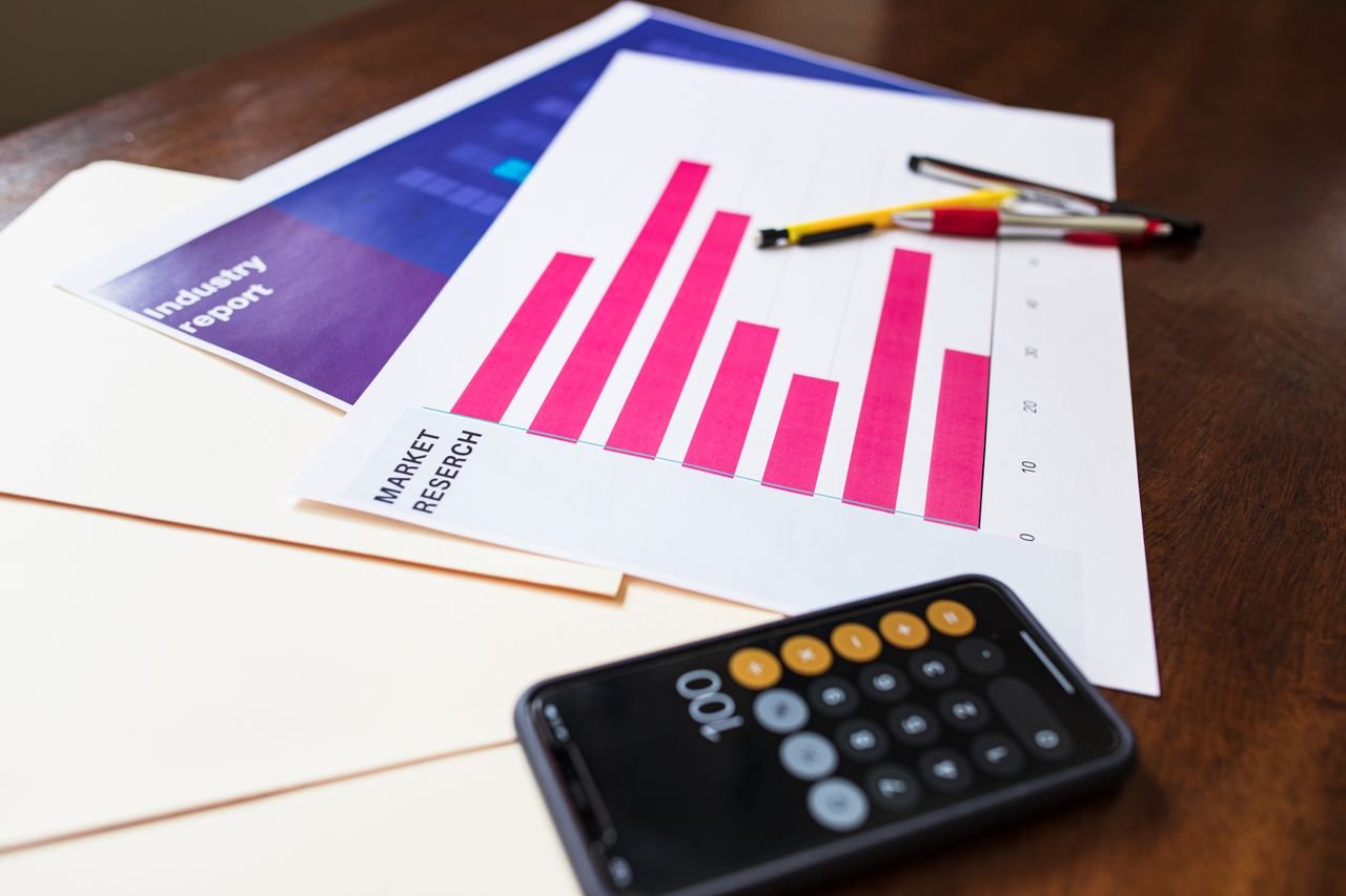 Illustrative market research chart and calculator on wooden desk for business analysis.